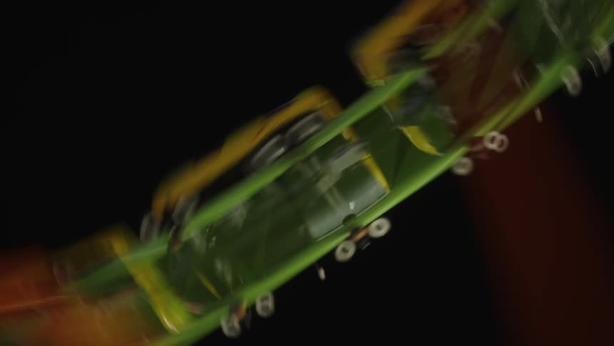 Group of people on a roller coaster ride in an amusement park at night