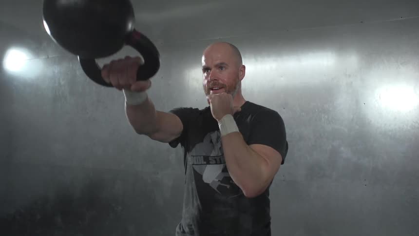 A man swinging a kettlebell