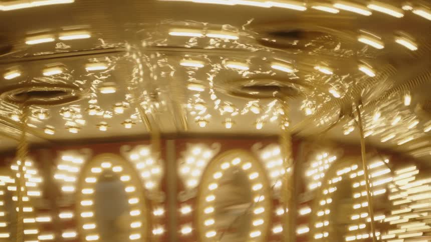 Illuminated amusement park ride moving at night