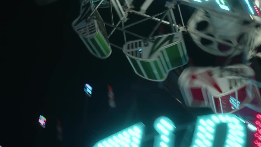 Upward view of a small ferris wheel at an amusement park at night