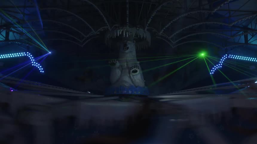 Amusement park with spinning ride and ice bear in the background