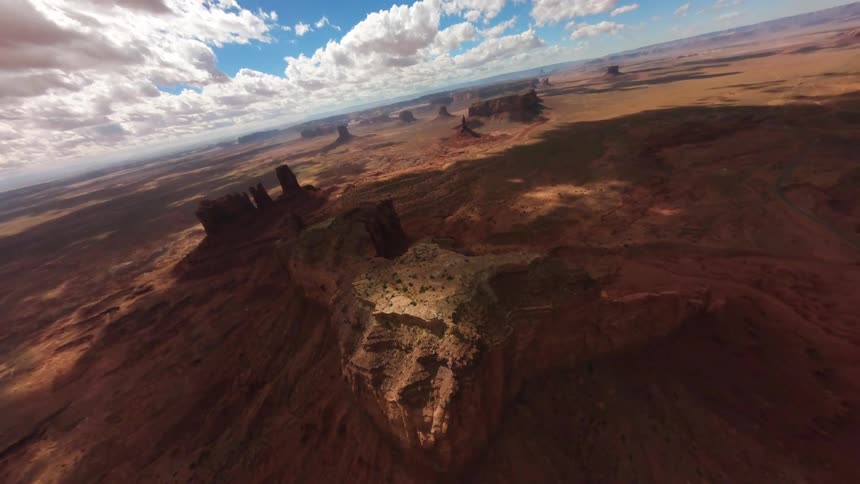 Aerial panorama of canyons against a blue sky with clouds