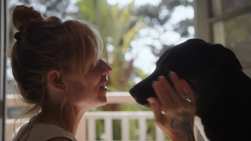 Her dog licks her and she pets it