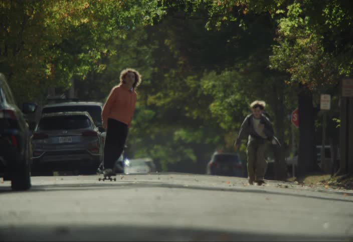 Teenager and a boy friends skateboarding on an urban street