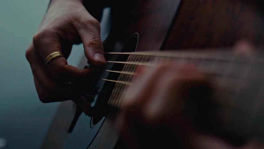 A man is playing his guitar