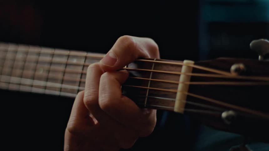 Male hand holding and playing guitar