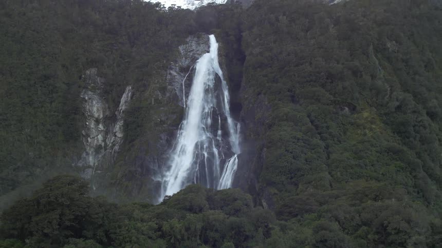 View of a lake, trees, waterfall and mountains