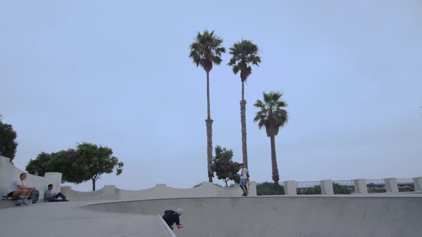 A man doing tricks on a bike at a skate park while others look on