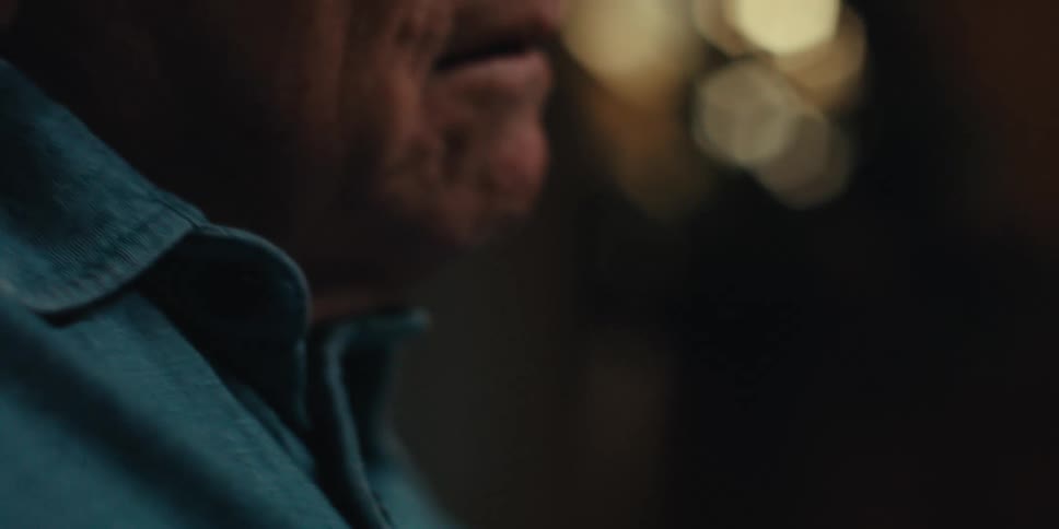 Elderly man smiles while reading a book at home
