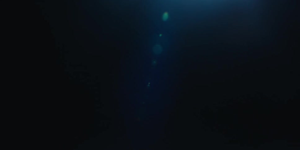 Wide beam of light from a bright source of light contrasts with the surrounding darkness