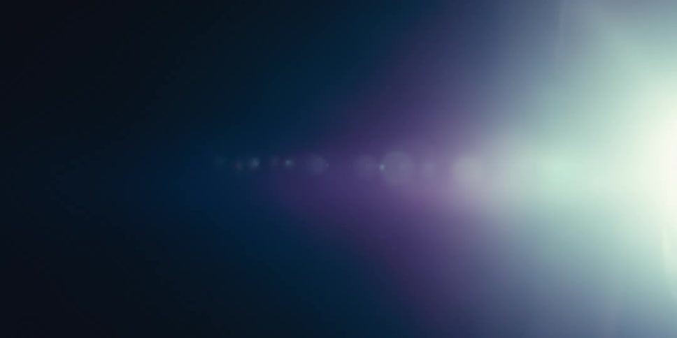 A bright light source with lens flares in a dark background