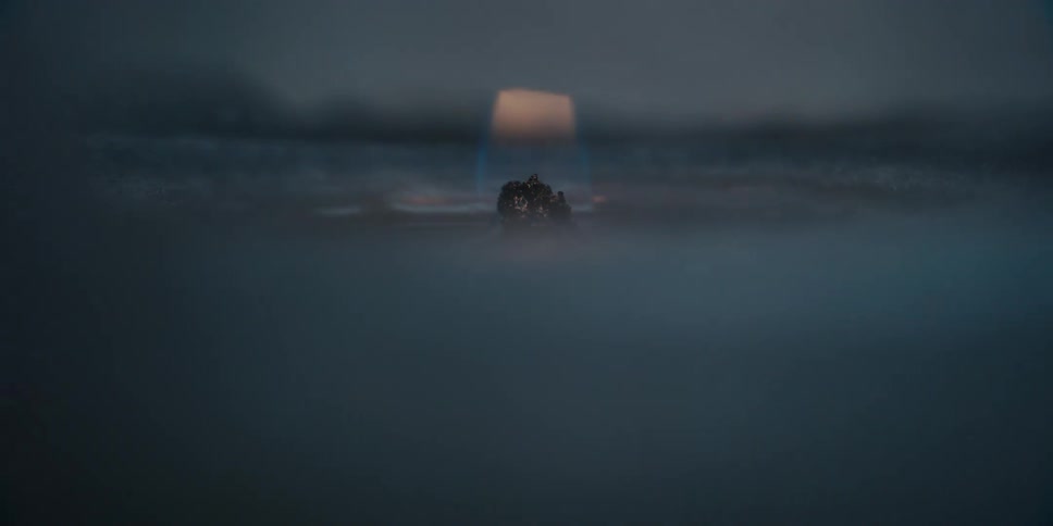 A candle burns in the dark