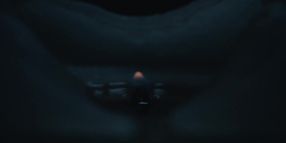 Close up of a candle with a small flame burning