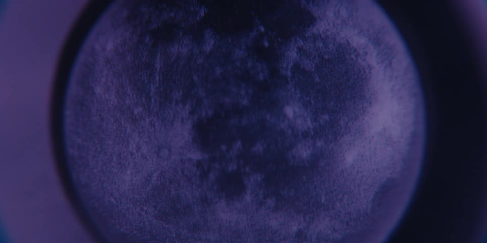 Closeup of a moon model illuminated by deep blue lighting