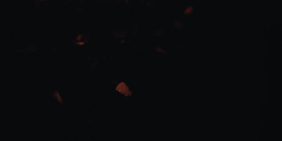 A cluster of crystals with warm glowing lights visible through a dark surface