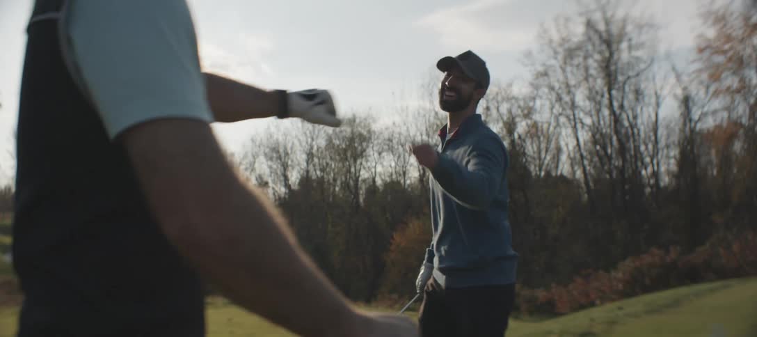 Two men celebrating and exchange high fives while playing golf