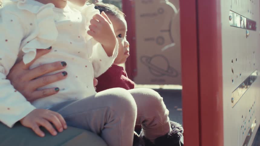 Adult accompanying his two children on a playground