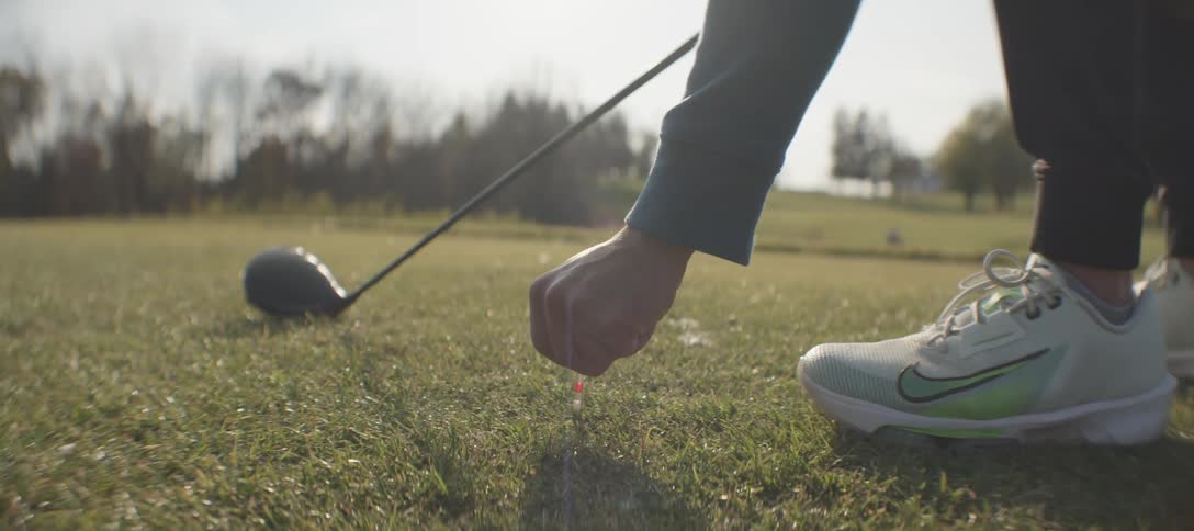 A man sets the golf ball on the tee