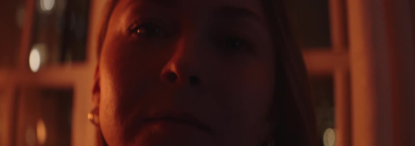 Face of a young woman in an indoor space at night