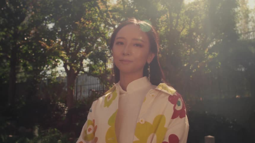 A woman poses wearing a floral shirt
