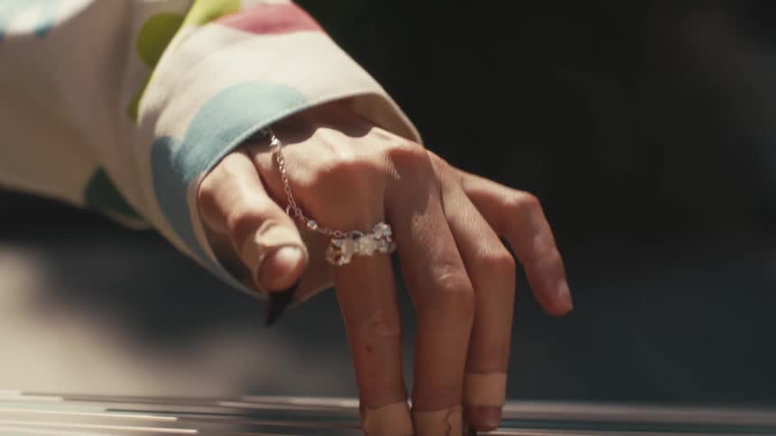 A womans hand with rings playing a guzheng a traditional chinese plucked string instrument