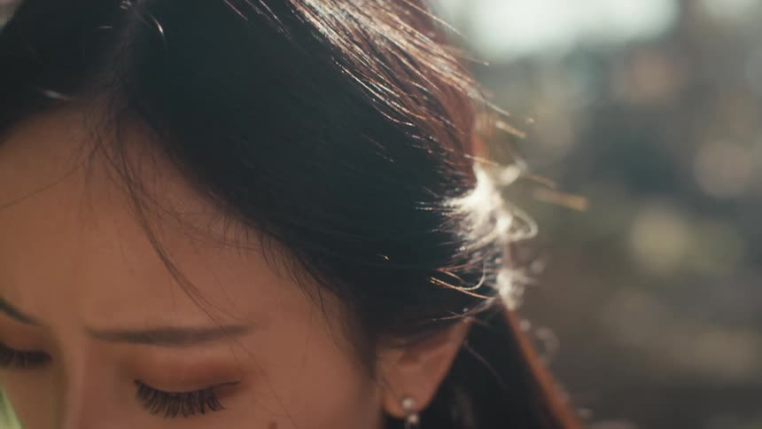 Portrait of a focused woman looking down while standing in an outdoor setting