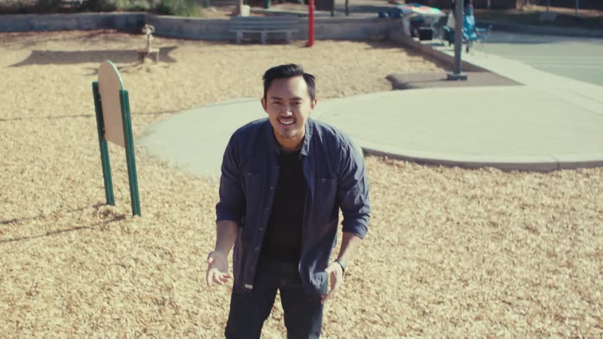 Man on an outdoor playground making hand signals