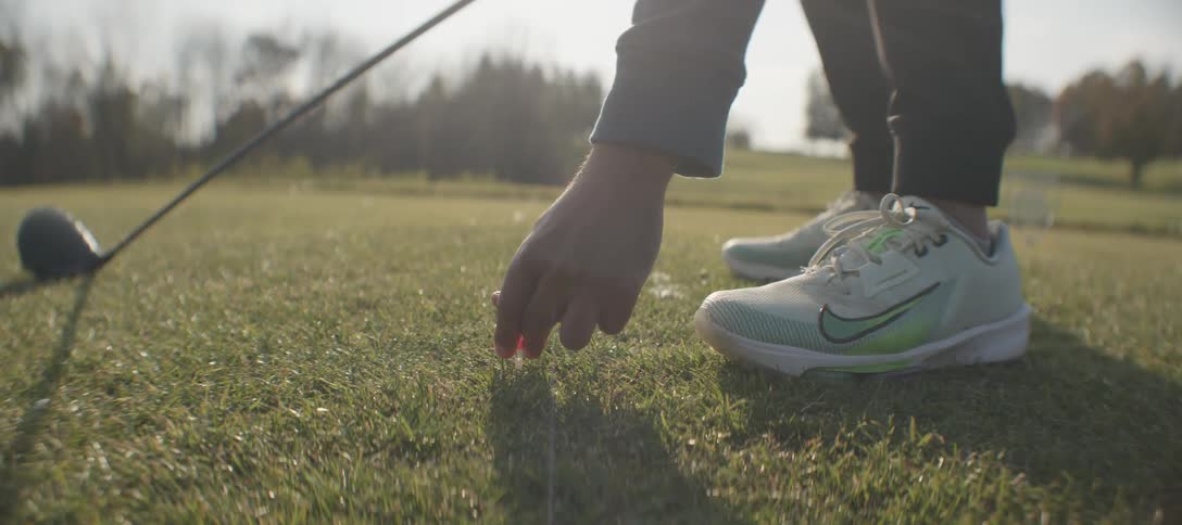 A golfer placing a golf ball on the tee ready to begin their swing