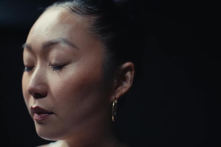 Closeup of an asian woman stretching her neck before starting a task