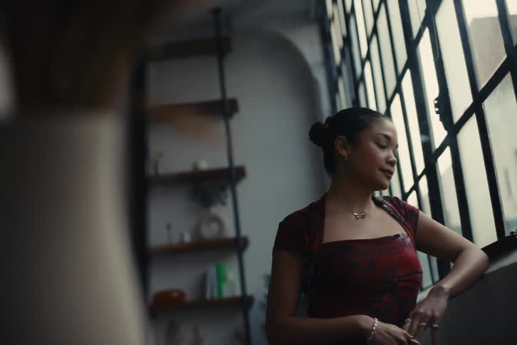 A woman is smiling as she looks out the window