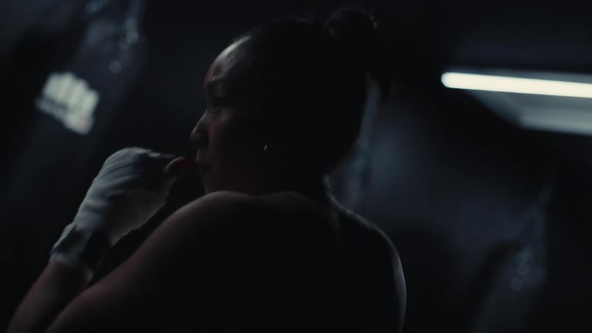 Woman in a gym throwing boxing punches in a training session
