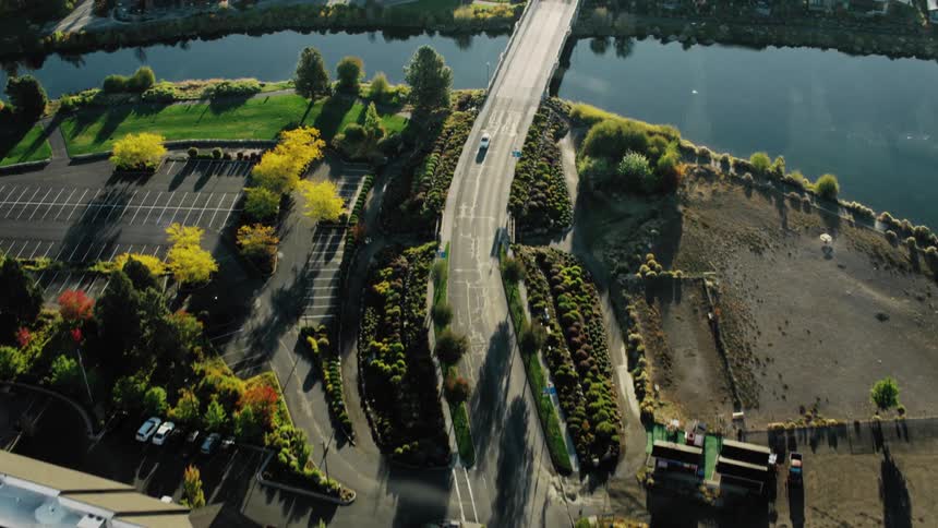 Aerial shot of a street with access to a bridge over a lake in an urban city