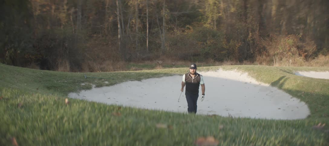 Man taking a golf swing on an outdoor course