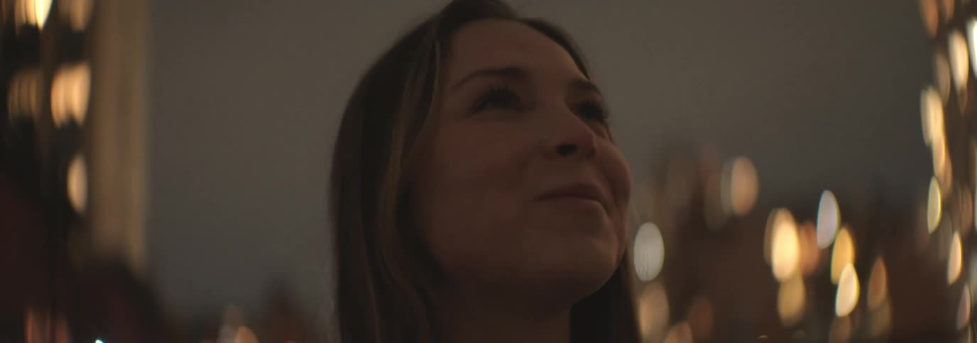 Woman in an outdoor area looking up with happy facial expression