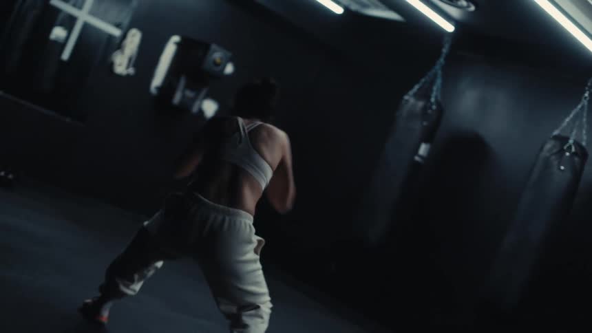 Woman has an indoor space training boxing punches