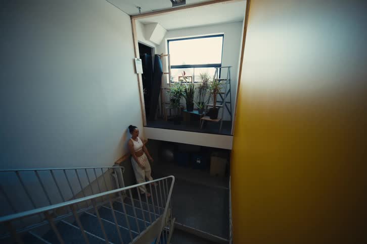 A female is stretching her arms in a stairwell