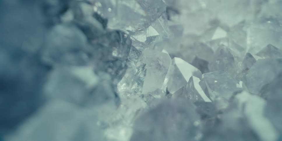 A closeup shot of ice crystals with light passing over them causing them to shimmer and sparkle