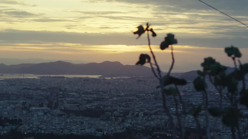 A metropolitan area is seen from an overlook at sunset