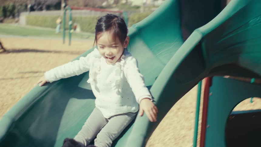 A girl is having fun using the slide in the playground