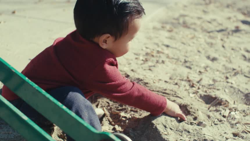 Little boy playing in the sand at a playground