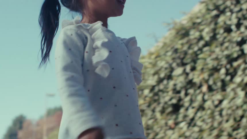 A girl walks from the playground to talk with her father