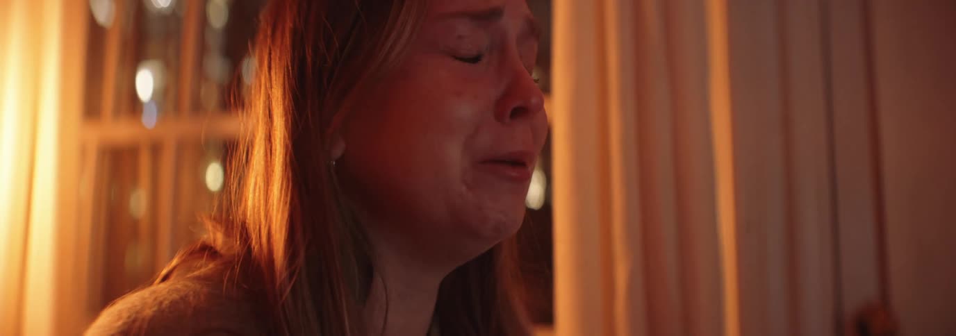 Portrait of a woman in a room crying