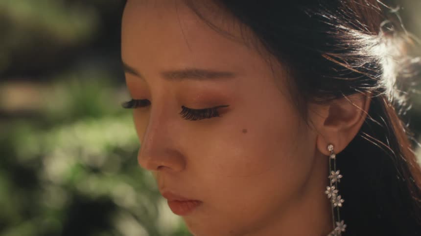 A woman looks down outdoors