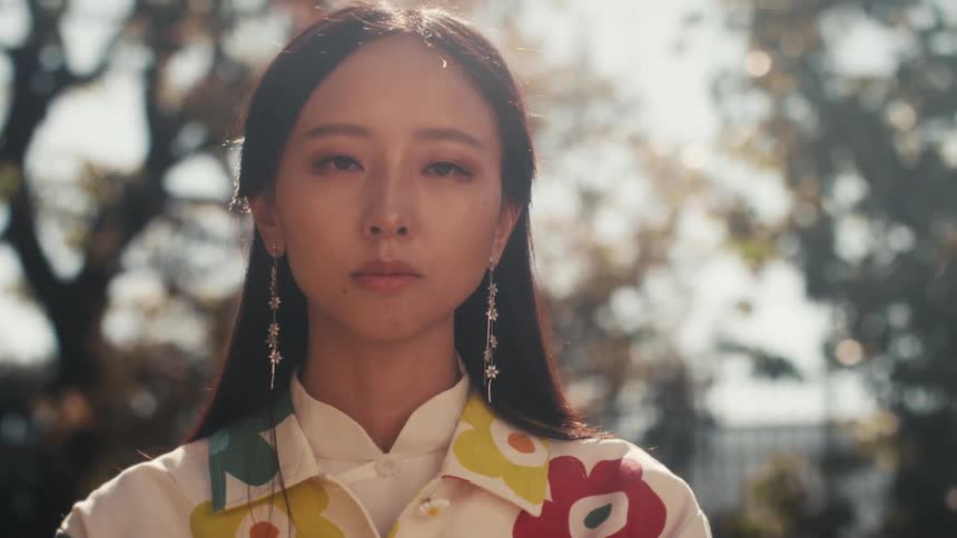 Portrait of a young woman in a white floral outfit outdoors