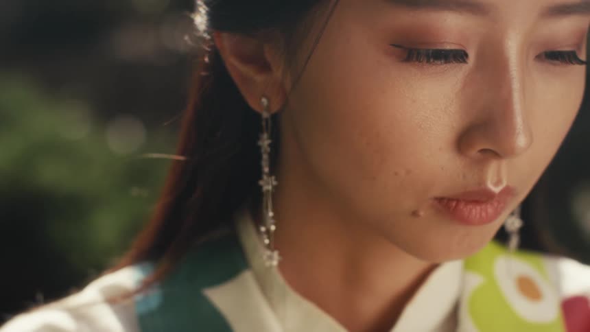 Closeup of a beautiful asian girl standing outdoors on a sunny day