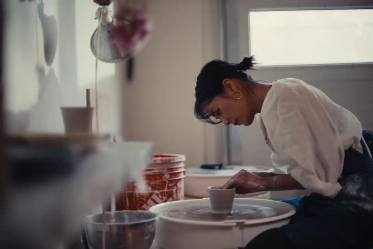 Woman making a clay vase