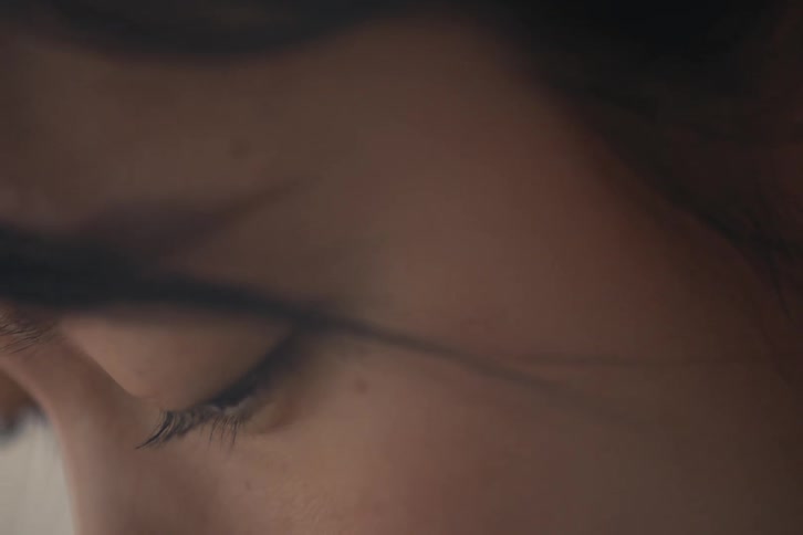 Closeup of a womans side face looking down and concentrating