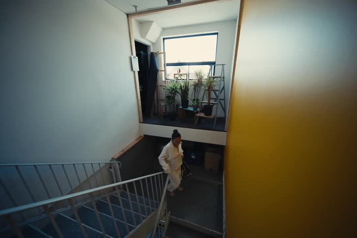 Woman with a bag walking down the stairs