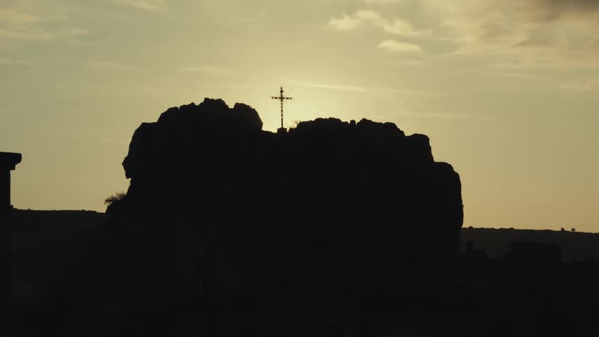 A clip of a crucifix on top of a hill