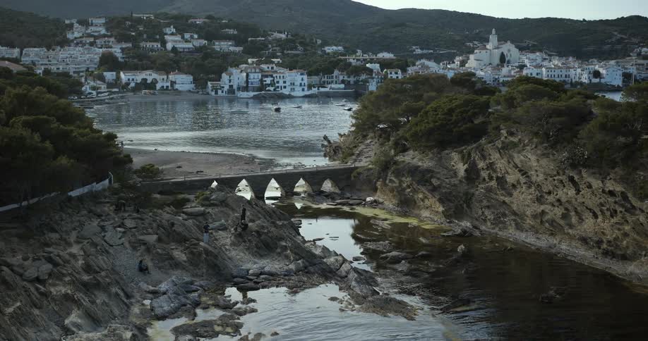 A scenic view of a serene coastal village with white houses and rocky shores
